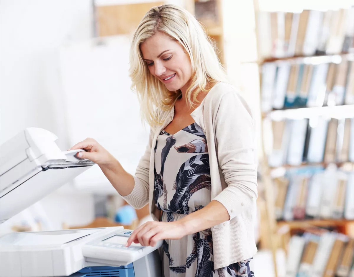 Woman standing at the photocopier on the subject of the office